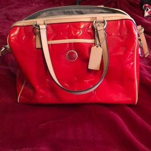 Bright red with tan trim, leather coach handbag.